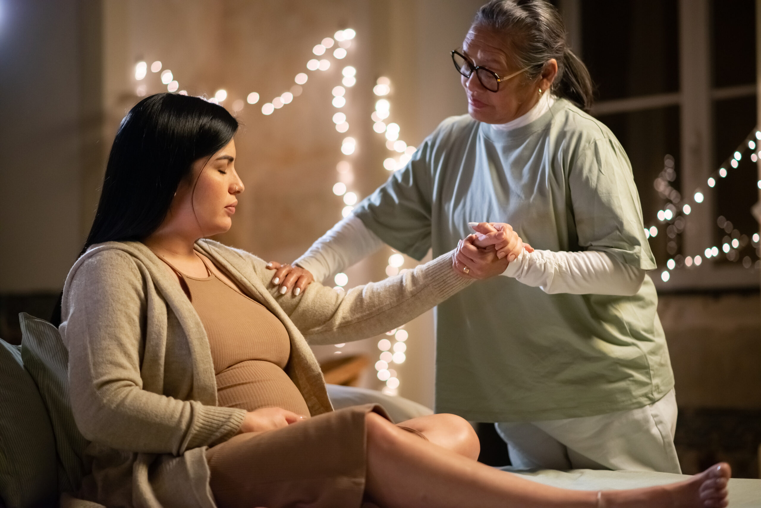 Doula and pregnant woman at home as the doula offers the woman emotional support.