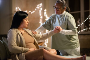 Doula and pregnant woman at home as the doula offers the woman emotional support.